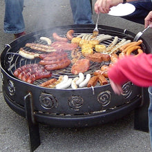 Laden Sie das Bild in den Galerie-Viewer, Grillrost Ø 75 cm für eine Design Feuerschale aus Edelstahl Rund. Auf dem Grillrost liegt viel Grillgut
